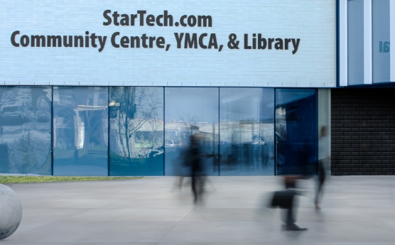 Image of YMCA building with people walking in front